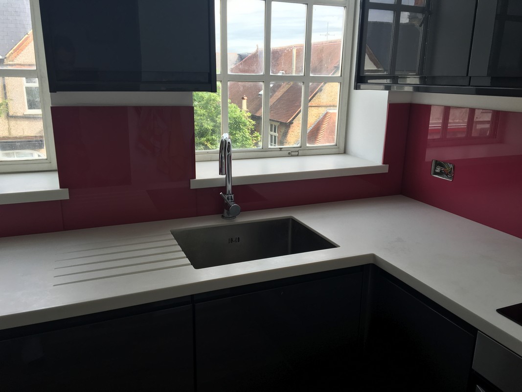 Deep plum coloured glass splashback in modern Bloomsbury kitchen